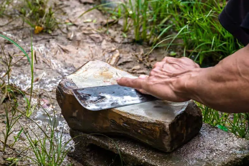 sharpening knife on stone outdoors