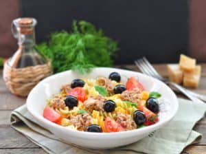 pasta salad with sauce and fork background