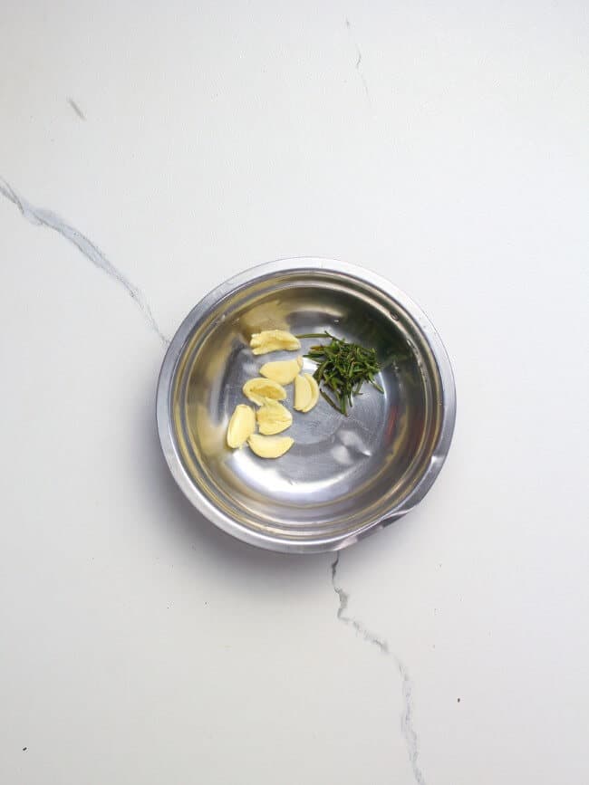 Garlic and rosemary in a mixing bowl