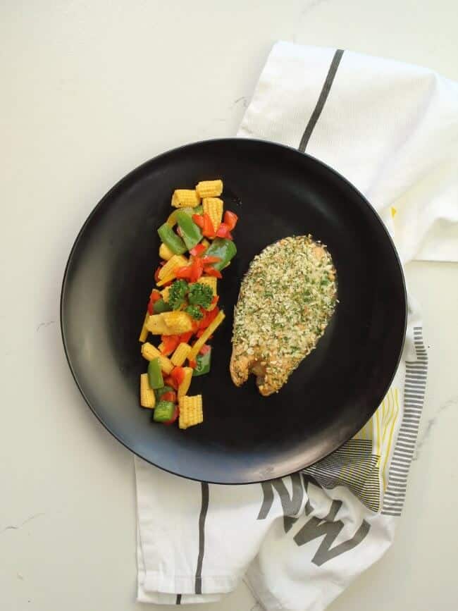 herb crusted baked salmon on black plate