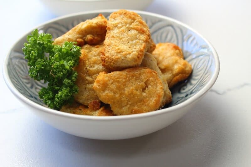 Golden brown chicken nuggets in a serving bowl