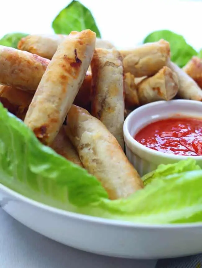 Close shot of egg rolls with chili sauce