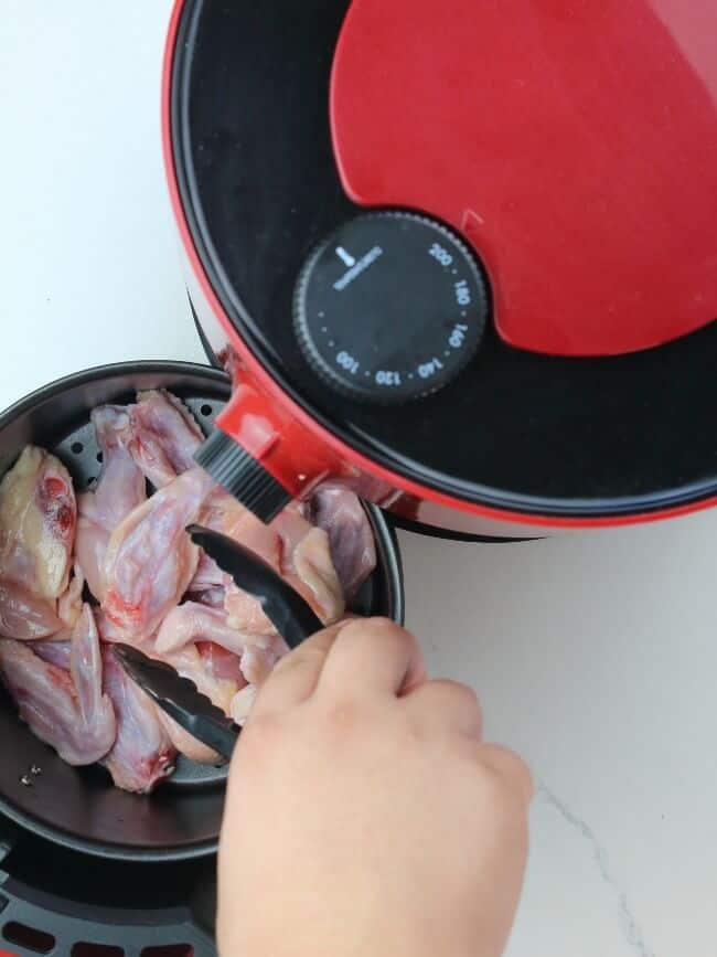 placing chicken inside the air fryer