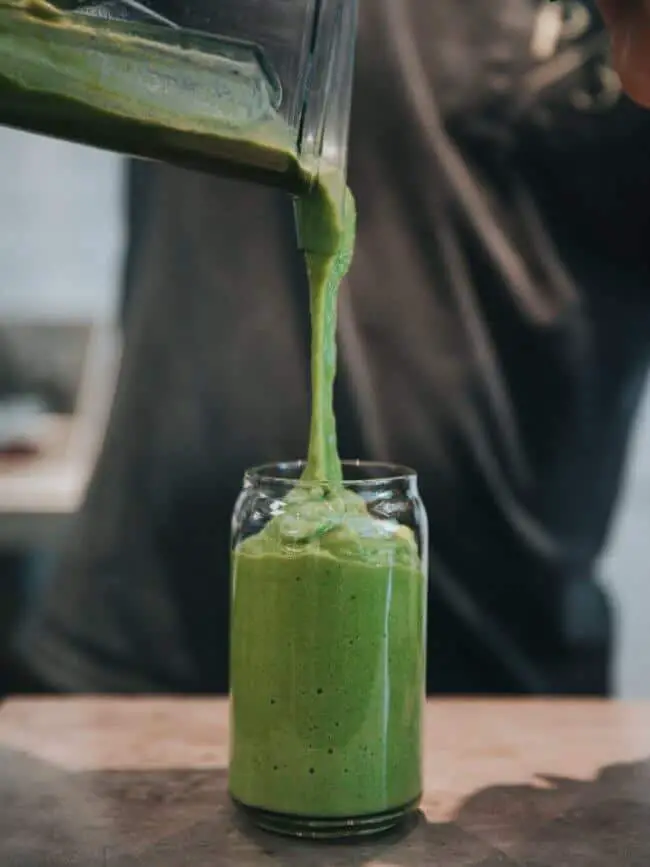 pouring healthy green smoothie