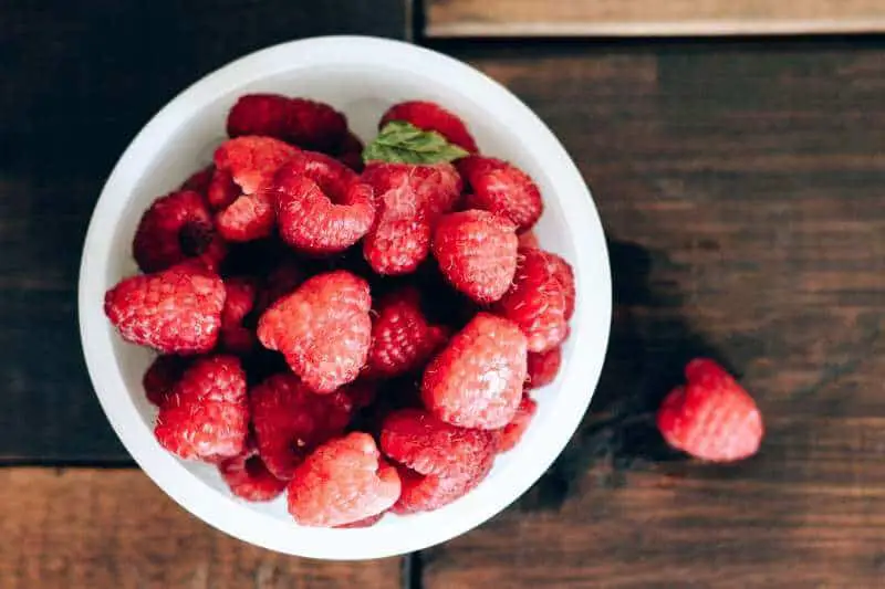 red raspberries in white bowl