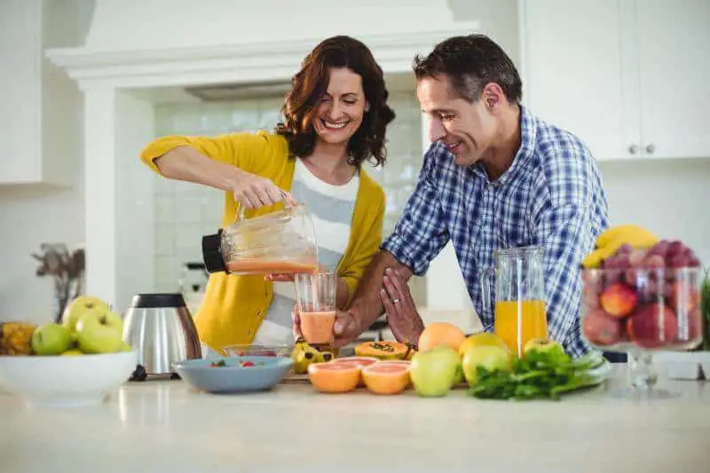 couple preparing smoothie in the kitchen