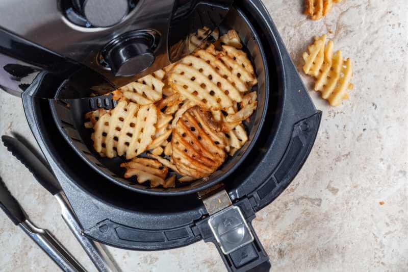 air fryer basket with fried potato slices