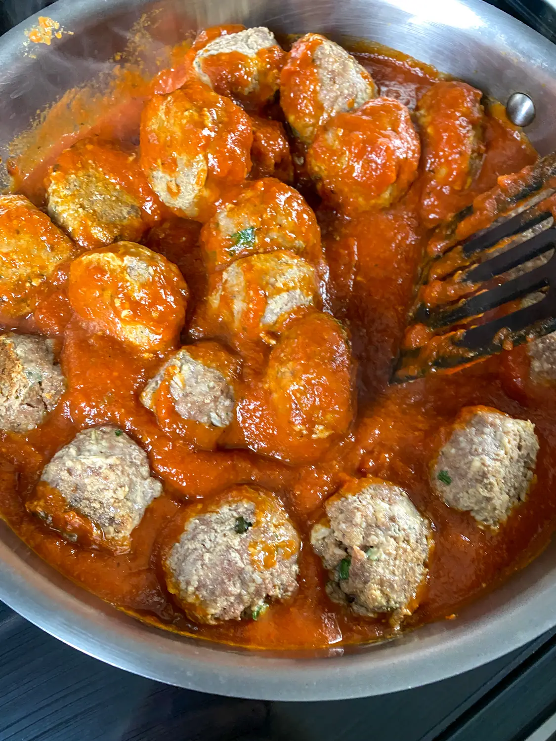 As the marinara sauce is heated, carefully turn the meatballs to coat in the sauce.